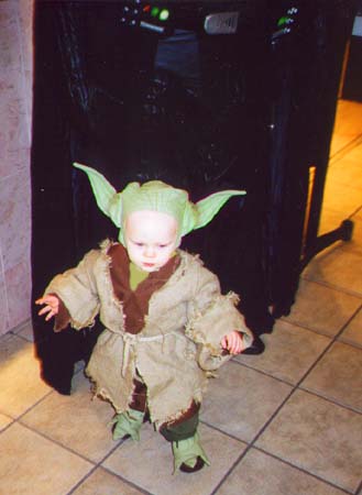 A baby dressed up in a Yoda costume