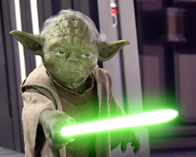 Yoda pointing his lightsaber at Sidious